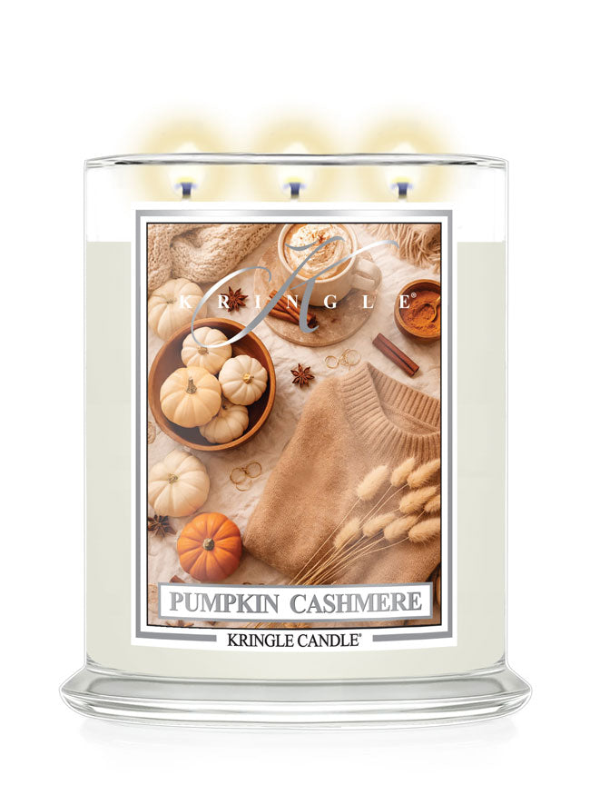 Kringle Candle with a label featuring small pumpkins, cinnamon and sweater on a white background
