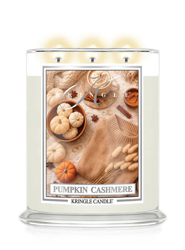 Kringle Candle with a label featuring small pumpkins, cinnamon and sweater on a white background