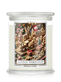 A Kringle Candle jar candle with a clear glass container featuring a festive label that reads 'Santa's Workshop' with a holiday workshop illustration.