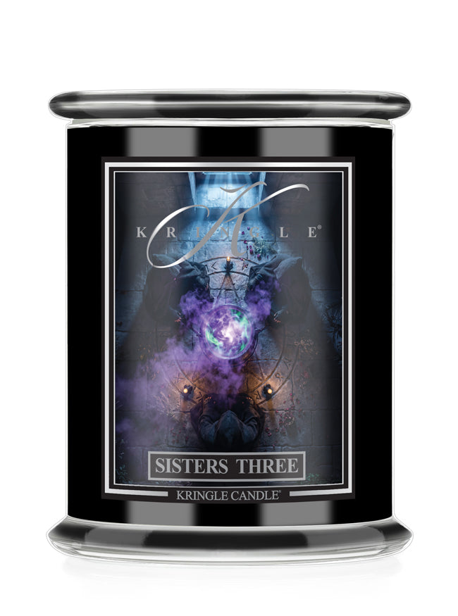 A black glass jar candle  for Kringle Candle's 'Sisters Three' Halloween scent. The label displays a dark, mystical graphic with purple and blue cosmic elements.