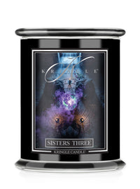 A black glass jar candle  for Kringle Candle's 'Sisters Three' Halloween scent. The label displays a dark, mystical graphic with purple and blue cosmic elements.
