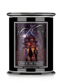 A black glass jar candle featuring a Halloween-themed label that reads 'Kringle' and 'Trick or Treat'. The label depicts three children standing in front of a haunted house in a dark, spooky forest.
