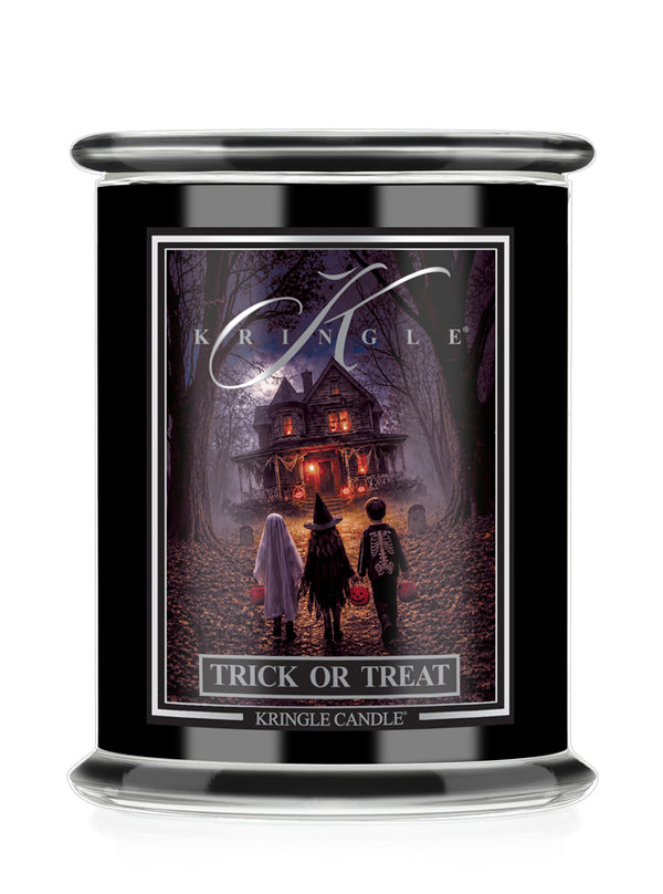 A black glass jar candle featuring a Halloween-themed label that reads 'Kringle' and 'Trick or Treat'. The label depicts three children standing in front of a haunted house in a dark, spooky forest.