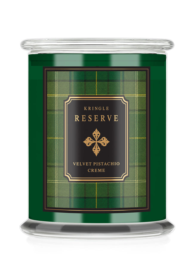 A Kringle Reserve candle in a clear glass jar with a green label featuring a tartan plaid pattern and a black central label with gold lettering.