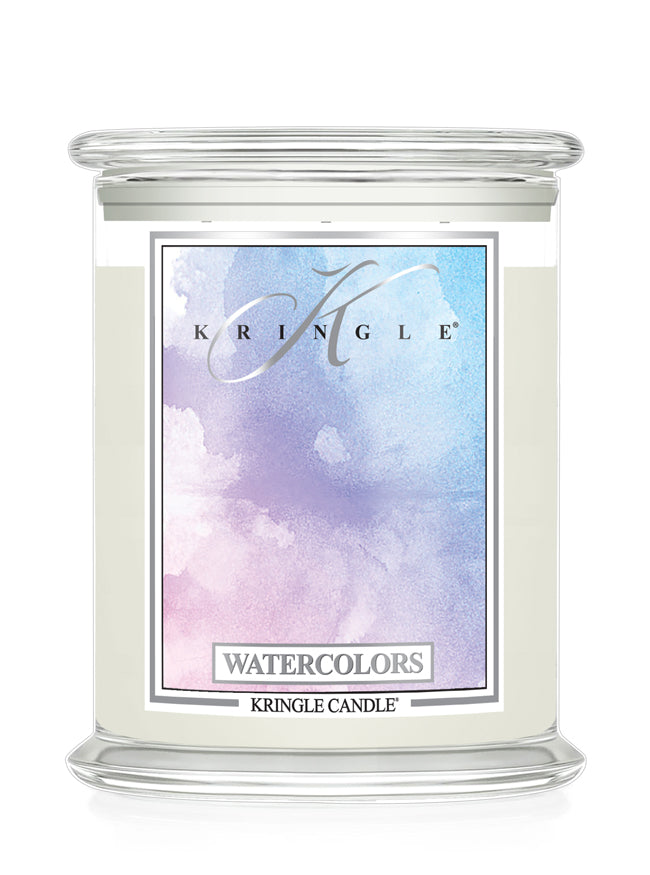 A Kringle Candle in a clear glass jar with a white wax fill and a colorful watercolor label featuring shades of blue, purple, and pink, labeled 'Watercolors'.