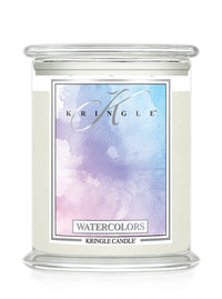 A Kringle Candle in a clear glass jar with a white wax fill and a colorful watercolor label featuring shades of blue, purple, and pink, labeled 'Watercolors'.