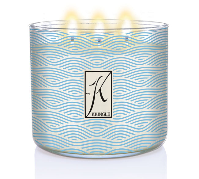 Sea Salt & Tonka 3-wick lit candle in a jar with blue wavy linel patterns and a silver lid. Central logo reads "Kringle."
