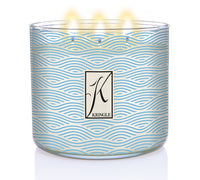 Sea Salt & Tonka 3-wick lit candle in a jar with blue wavy linel patterns and a silver lid. Central logo reads "Kringle."