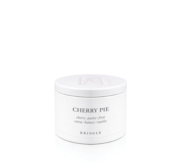 A white round candle tin with a matching lid, labeled 'CHERRY PIE' by the brand KRINGLE, on a seamless white background.