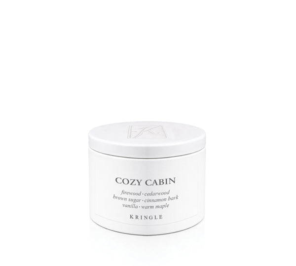A white cylindrical metal candle tin of Kringle Cozy Cabin scented candle wax with black text on a clean white background.