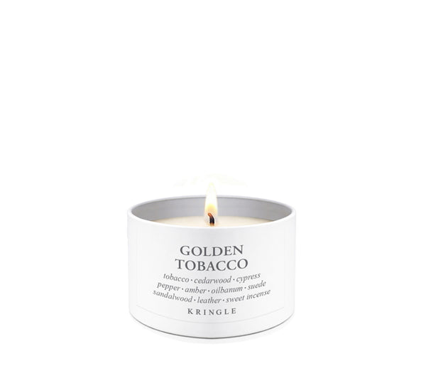 A lit white candle in a cylindrical white tin labeled 'GOLDEN TOBACCO' by Kringle, shown on a clean white background.