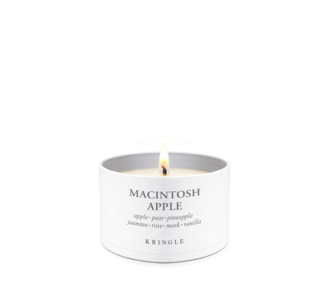 White candle in a tin container labeled 'Amber Wood' by Kringle on a white background