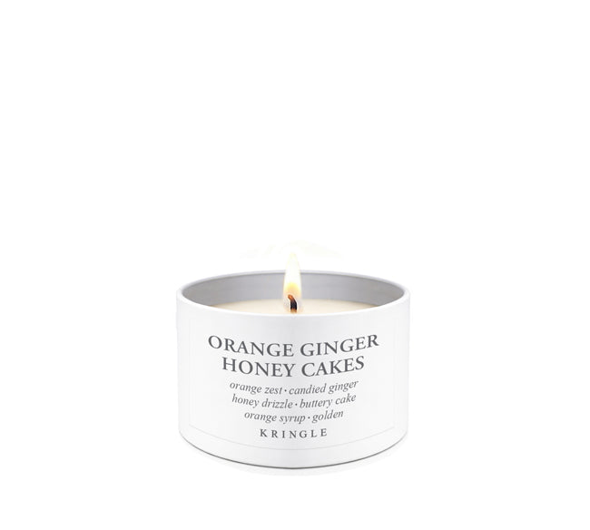 Candle labeled 'Orange Ginger Honey Cakes' by Kringle on a white background