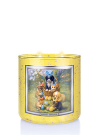Decorative candle with Easter-themed illustration of animals and eggs on a yellow background