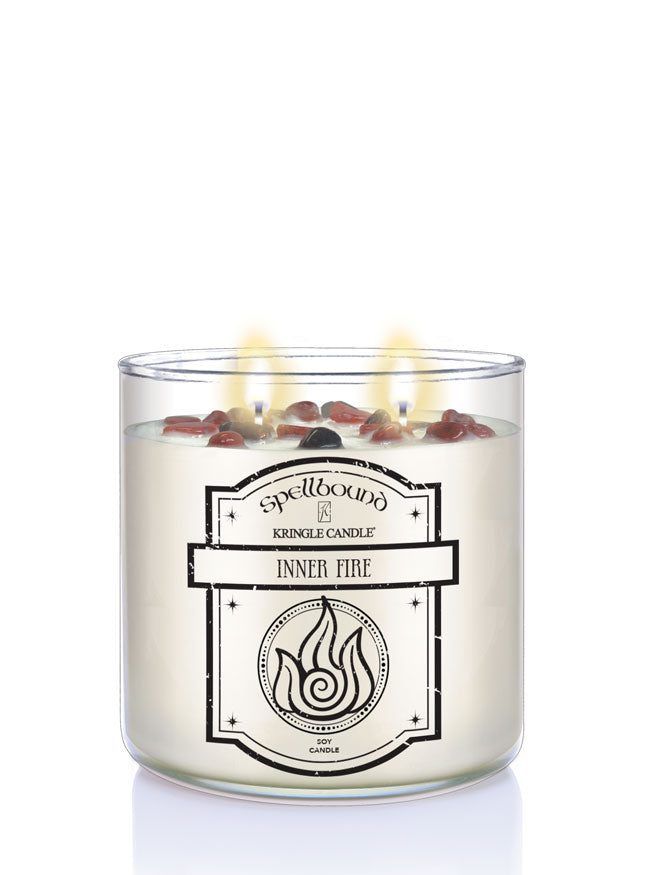 Spellbound Inner Fire lit candle with silver lid on a white background