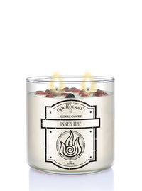Spellbound Inner Fire lit candle with silver lid on a white background
