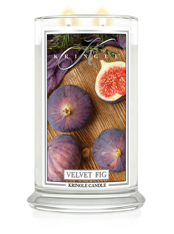 Lit Velvet Fig 2-wick candle. Label shows whole and half figs on wood with herbs.