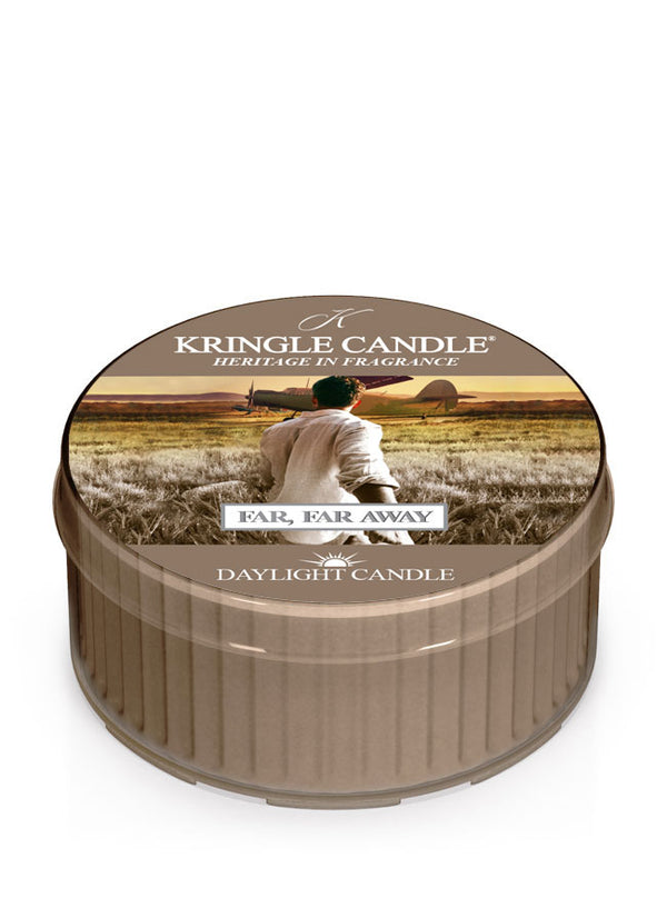 Kringle Candle's Far, Far Away citrus scented Daylight candle with a label showing a man holding a woman's hand and leading her away to take a flight on a prop plane off in the distance.