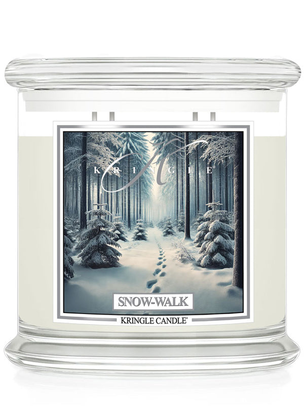 Kringle Candle 4-wick in clear glass with "Snow-Walk" label, featuring a snowy forest path scene.
