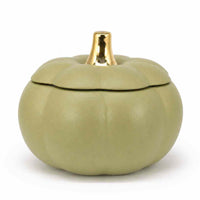 A small pumpkin-shaped lidded container in a muted sage green color with a shiny gold metallic stem, set against a plain white background.