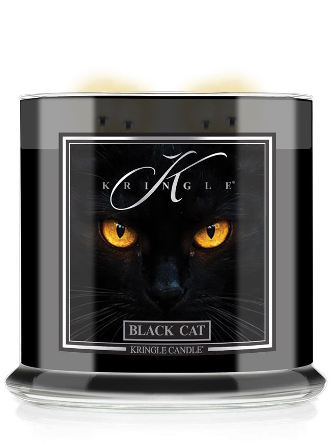 A Kringle Candle jar labeled 'Black Cat' featuring a dramatic graphic of a black cat with glowing yellow eyes on a black background, shown in a clear glass container with a black wax fill.