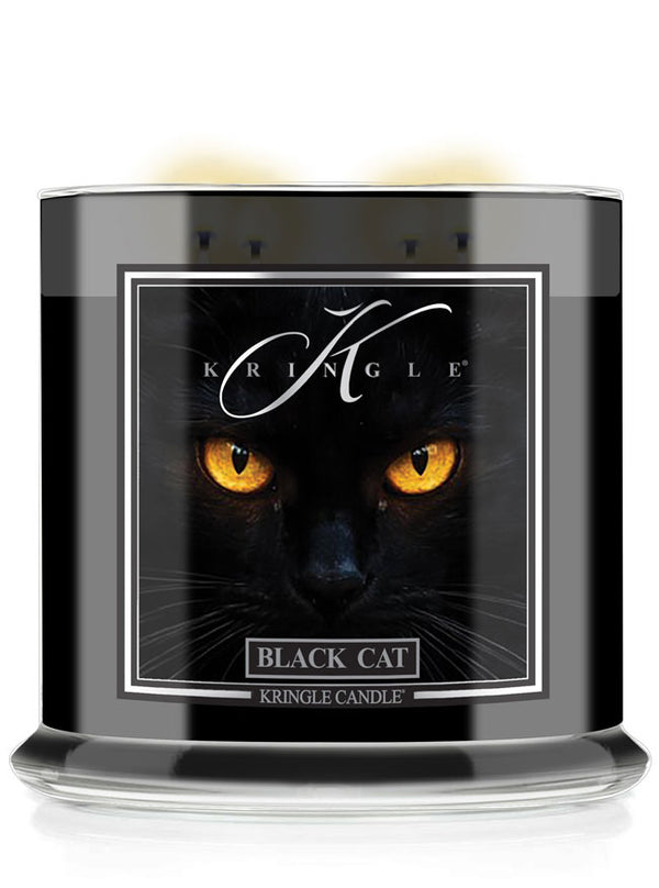 A Kringle Candle jar labeled 'Black Cat' featuring a dramatic graphic of a black cat with glowing yellow eyes on a black background, shown in a clear glass container with a black wax fill.