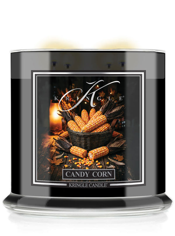 A Kringle Candle jar candle labeled 'Candy Corn' with a black container, clear glass base, and a front label showing corn on the cob, candles, and autumn imagery.