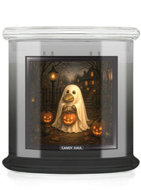 A large glass jar candle with a black base and a clear lid, featuring a Halloween-themed printed label. The label shows a ghost alligator holding a glowing jack-o'-lantern in a dark haunted house yard, with the words 'CANDY HAUL' printed below the artwork.