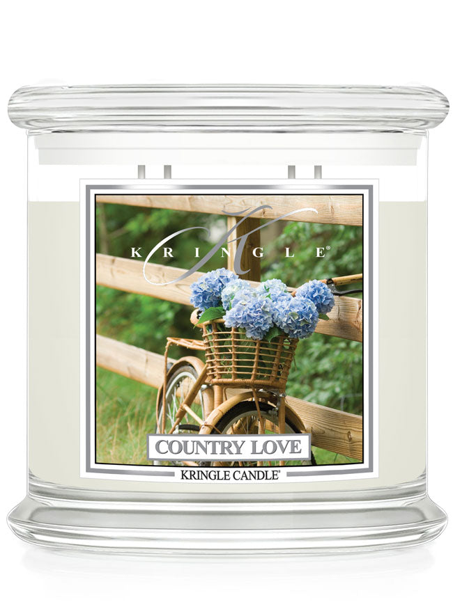 Kringle Candle with 'Country Love' design featuring a bicycle and flowers on a white background