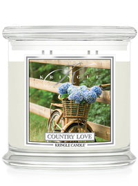 Kringle Candle with 'Country Love' design featuring a bicycle and flowers on a white background