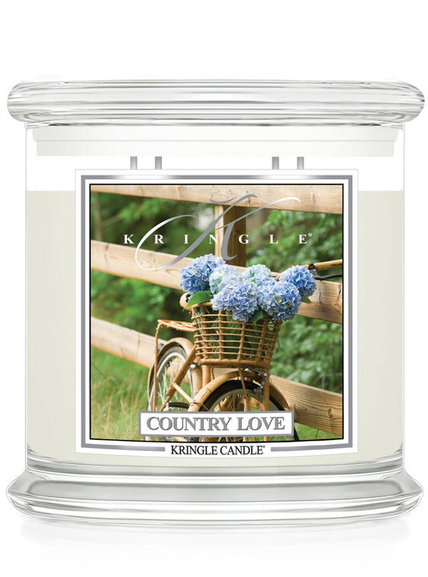 Kringle Candle with 'Country Love' design featuring a bicycle and flowers on a white background