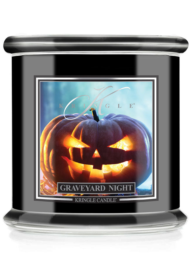 A Kringle Candle jar with a black body and lid, featuring a front label that reads 'Graveyard Night' and shows a glowing jack-o'-lantern pumpkin against a blue-toned background.