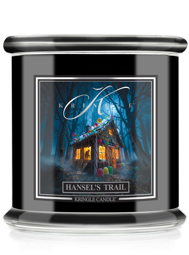 A Kringle Candle jar candle labeled 'Hansel's Trail' featuring a dark, whimsical forest cabin illustration with glowing windows and colorful balloons, shown on a clean white background.