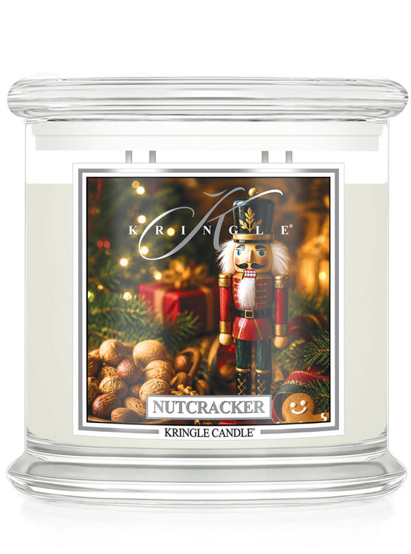 A Kringle Candle 'Nutcracker' scented candle in a clear glass jar with a white wax fill and a festive holiday label featuring a nutcracker, Christmas tree, ornaments, and gifts.