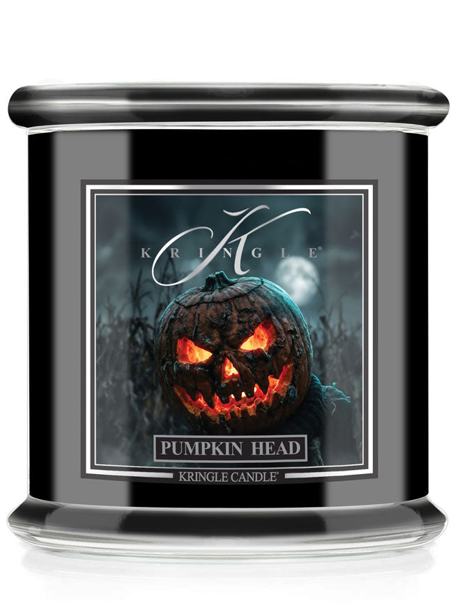 A Kringle Candle in a black glass jar featuring a Halloween-themed label that reads 'Pumpkin Head' with an illustration of a glowing jack-o'-lantern.