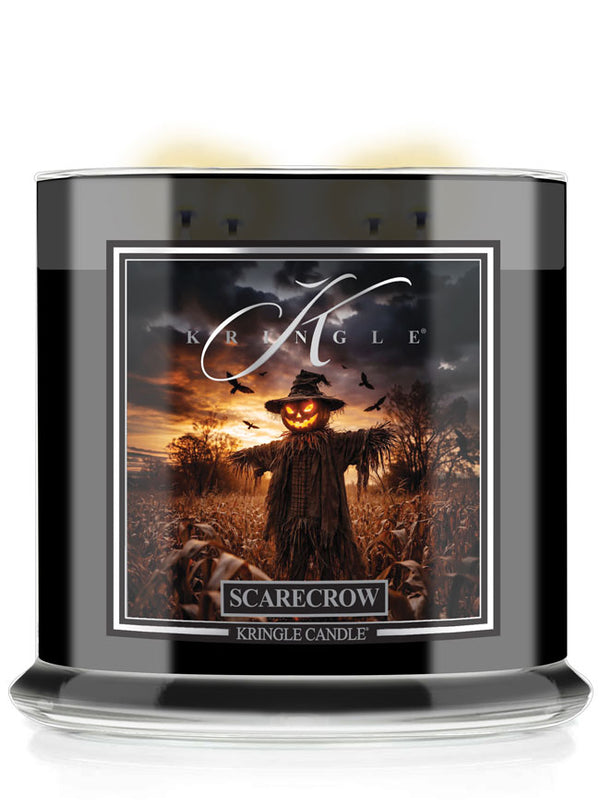 A Kringle Candle jar candle with a black glass container and a square label featuring a scarecrow in a field at sunset. The label reads 'Scarecrow' and 'Kringle Candle'.