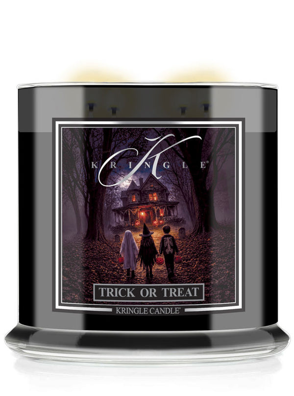 A Kringle Candle jar candle with a black container and a front label featuring a spooky haunted-house scene at night. The label reads 'KRINGLE', 'TRICK OR TREAT', and 'KRINGLE CANDLE'.