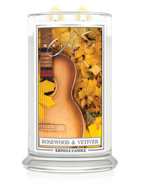 Lit 2-wick candle in clear jar; label shows guitar and yellow leaves. Fragrance: Rosewood & Vetiver.