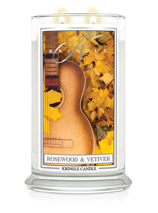 Lit 2-wick candle in clear jar; label shows guitar and yellow leaves. Fragrance: Rosewood & Vetiver.