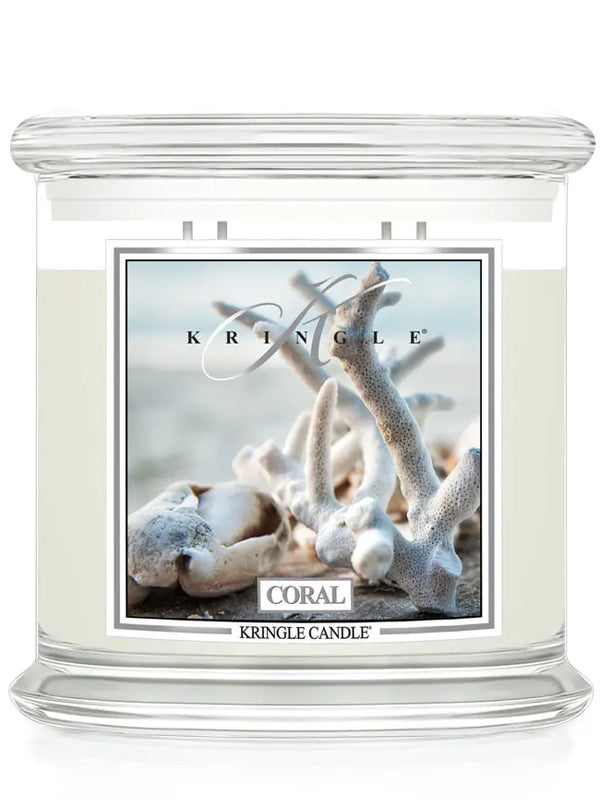 Kringle Candle jar in Coral scent featuring a coastal image of white coral branches on a beach.