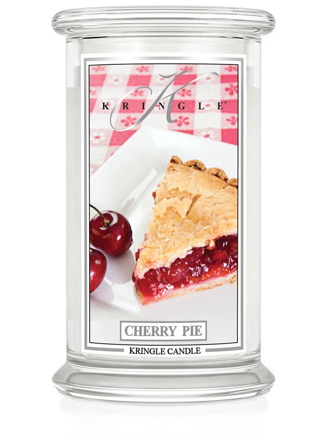 Kringle Candle’s Cherry Pie jar featuring a slice of cherry pie and fresh cherries on a white plate with a red checkered background.
