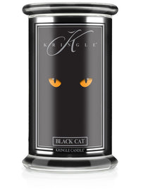 Unlit Halloween candle in glass jar. Label shows glowing yellow cat eyes on black background. Text reads "Black Cat."