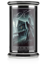 Unlit Halloween candle labeled "Cabin in the Woods" with eerie cabin and figure in a dark forest scene.