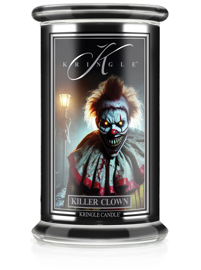 A lit Halloween candle in a glass jar with a "Killer Clown" label featuring a sinister clown and a glowing streetlamp in the…