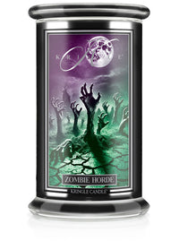 A large candle jar labeled "Zombie Horde," unlit, features eerie zombie hands rising from a cracked, greenish landscape.