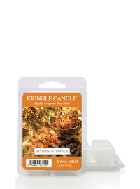 Kringle Candle Myrah & Tonka 6 wax melts in a clear clamshell package with an orange label, shown next to two small white wax melts on a white background.